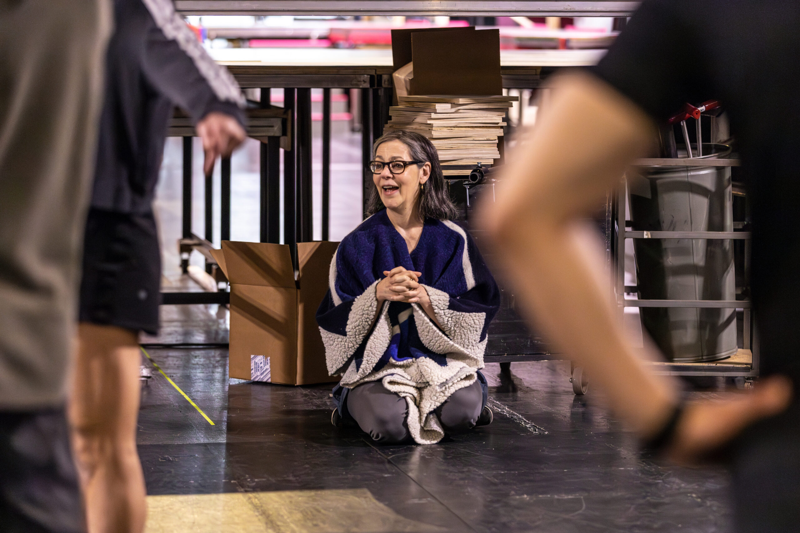 a woman sitting on the floor watching rehearsal