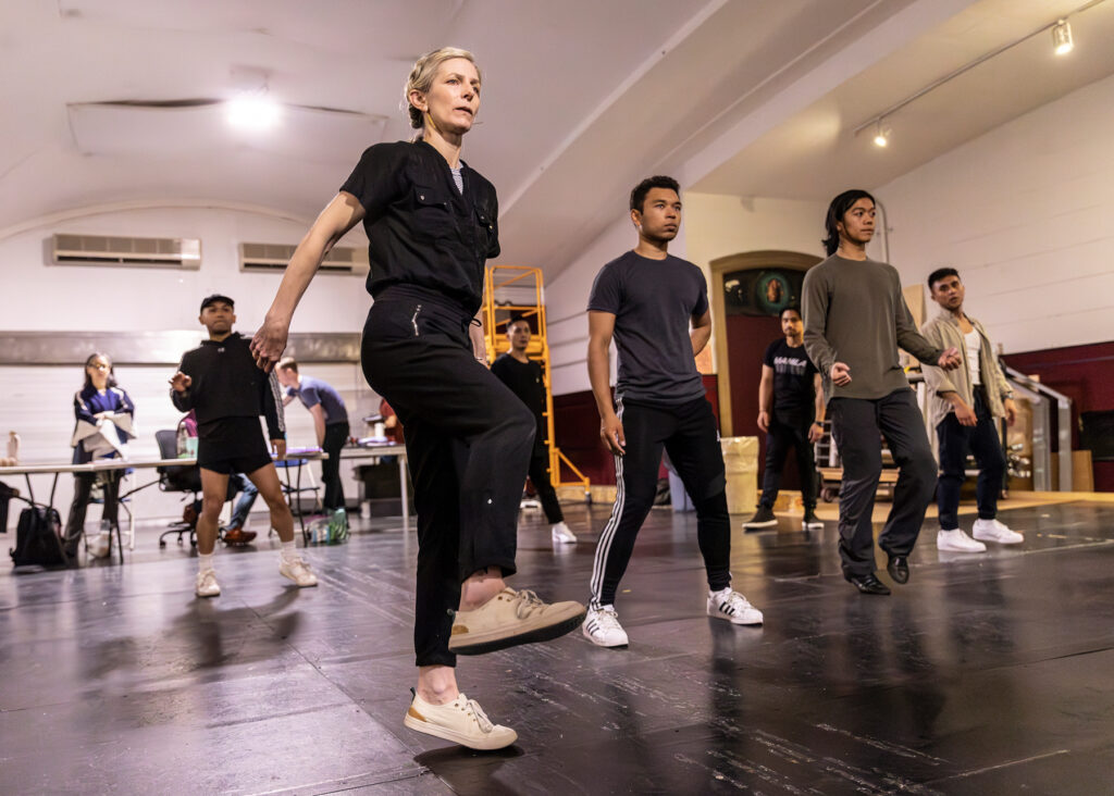 a blonde female demonstrating steps for a group of dancers