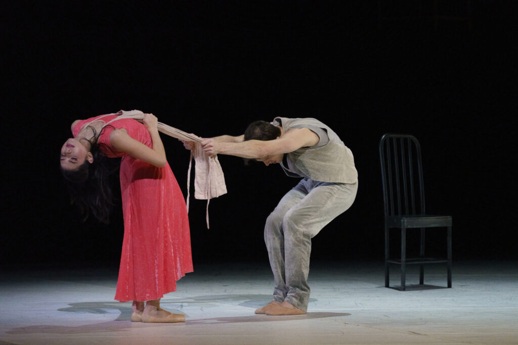 a male dancer pulling on an apron that a female dancer has around her neck