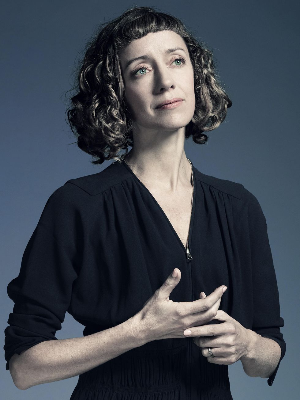 Cathy Marston, her curls cut into a chin-length bob and dressed in black, gazes contemplatively into the distance, one hand worrying at the other in front of her sternum.