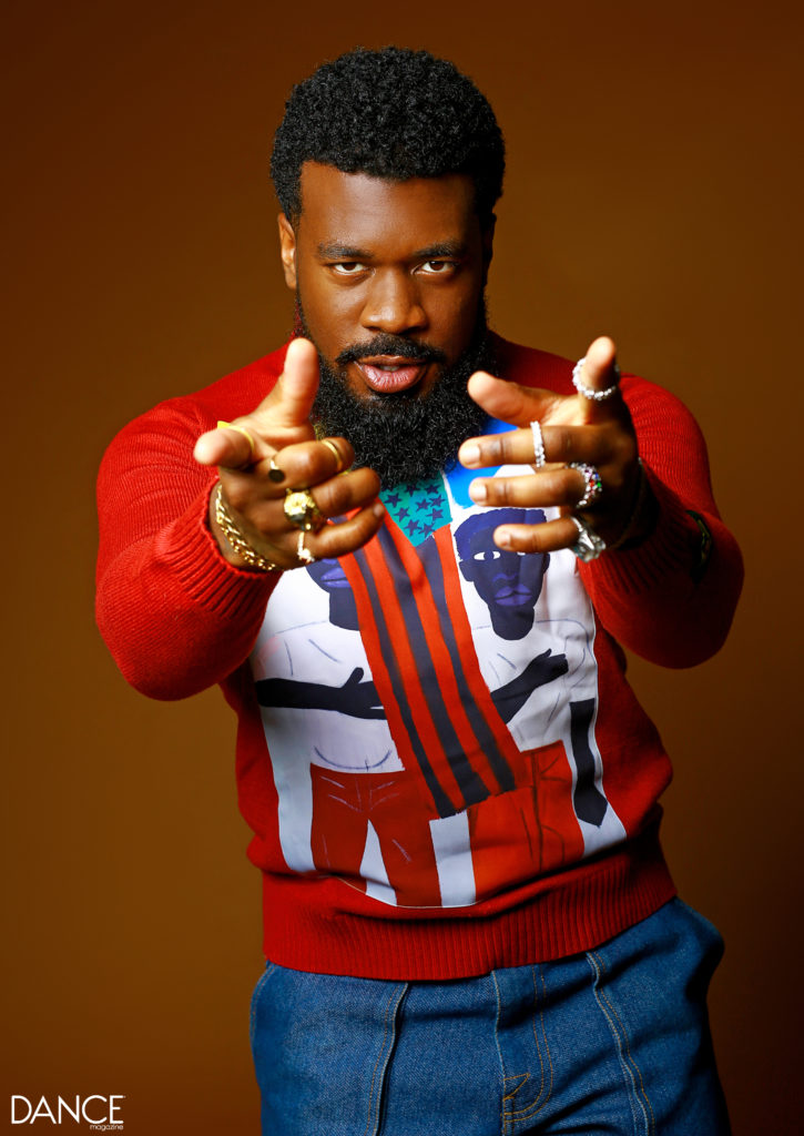Portrait of JaQuel Knight pointing at the camera, his chin tucked down, seen from the hips up