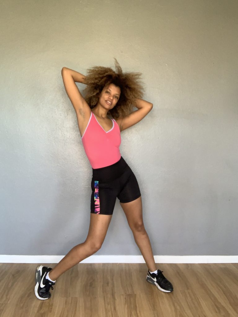 dancer in black bike shorts and pink leotard