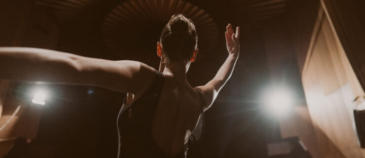 Photo of a ballerina performing on the stage of a theater.