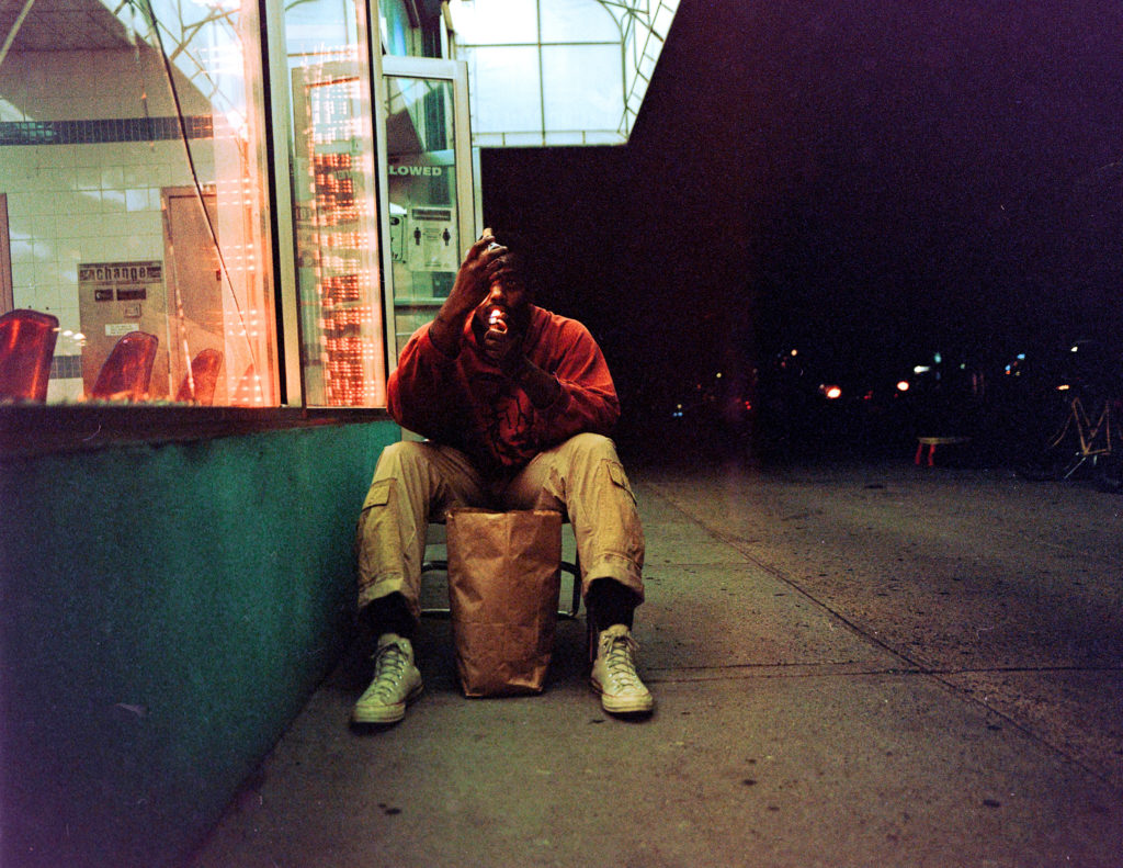 man sitting outside store smoking