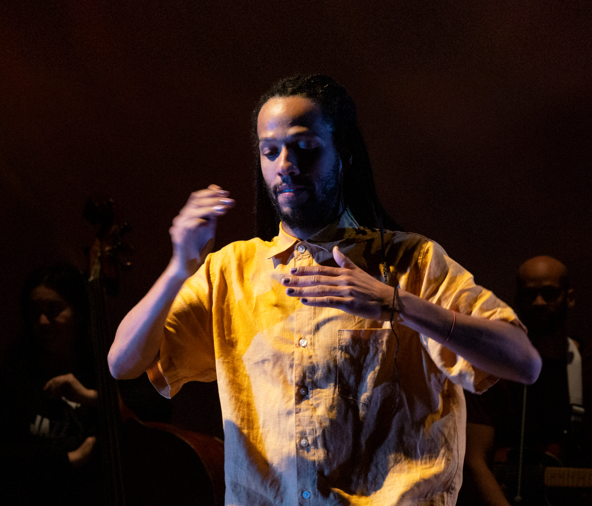 man wearing yellow button down performing body percussion