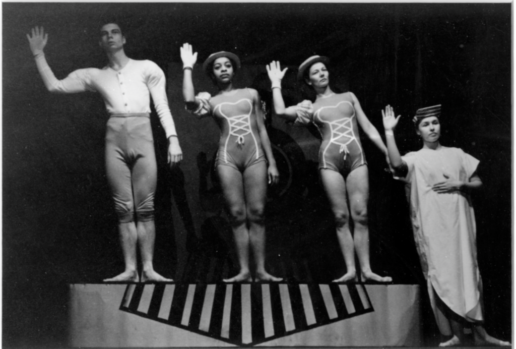 4 dancers holding up their right hand and leaning towards the right